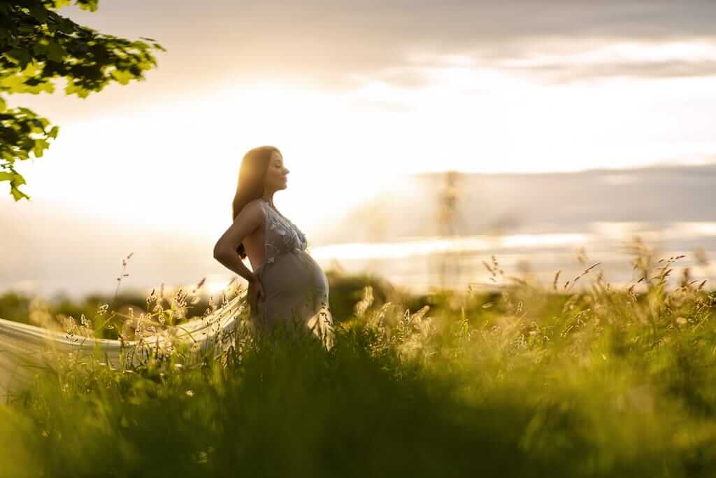 Photo de maternité, dans un champ, réalisée par une photographe à Granby.
