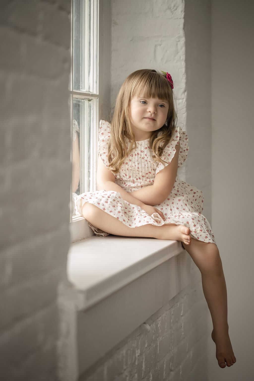 Séance photo d'une petite fille assise sur le bord d'une fenêtre dans un studio à Granby — Rébecca Vandal, photographe à Granby