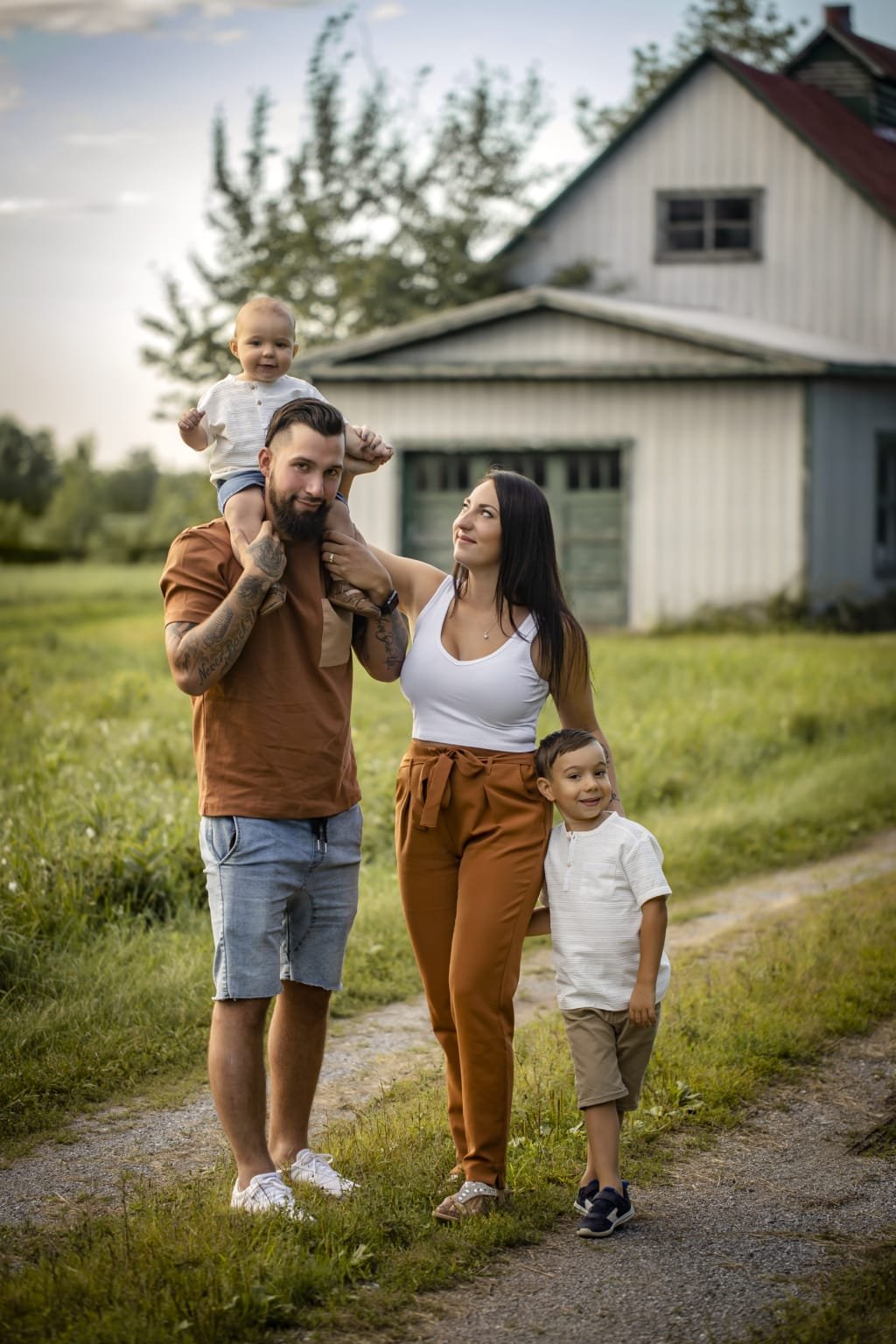 Famille devant une grange, papa porte le petit sur ses épaules — Rébecca Vandal, photographe à Granby