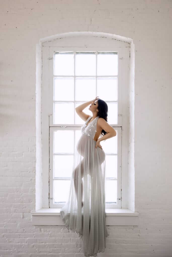 Photo fineart d'une femme enceinte dans une fenêtre, réalisé dans un studio à Granby.