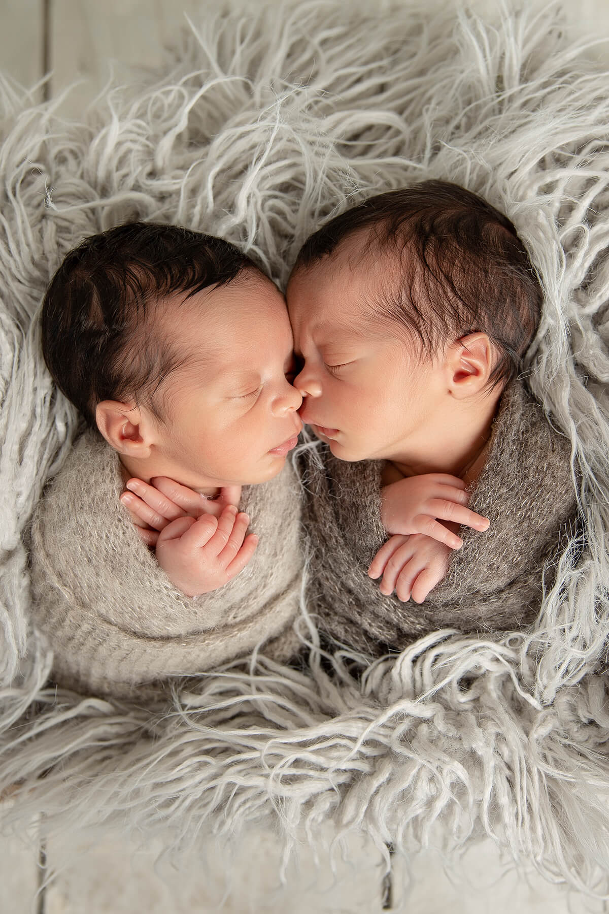 Deux jumeaux nouveau-nés enveloppés dans une couverture.