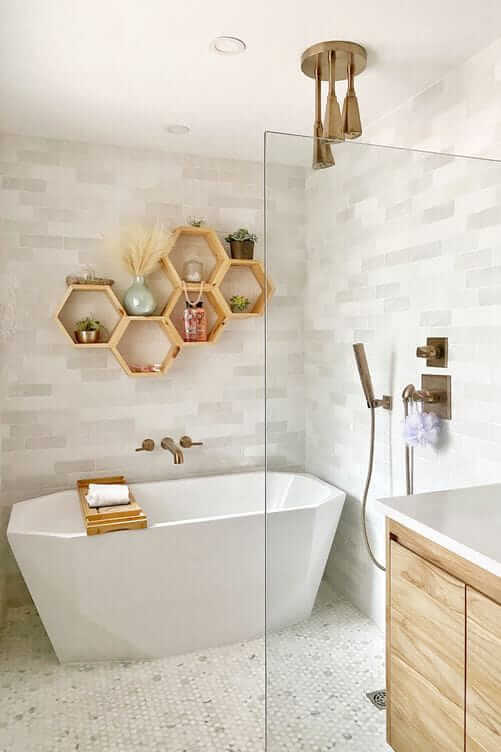 Une salle de bain blanche avec des étagères en bois et une baignoire.