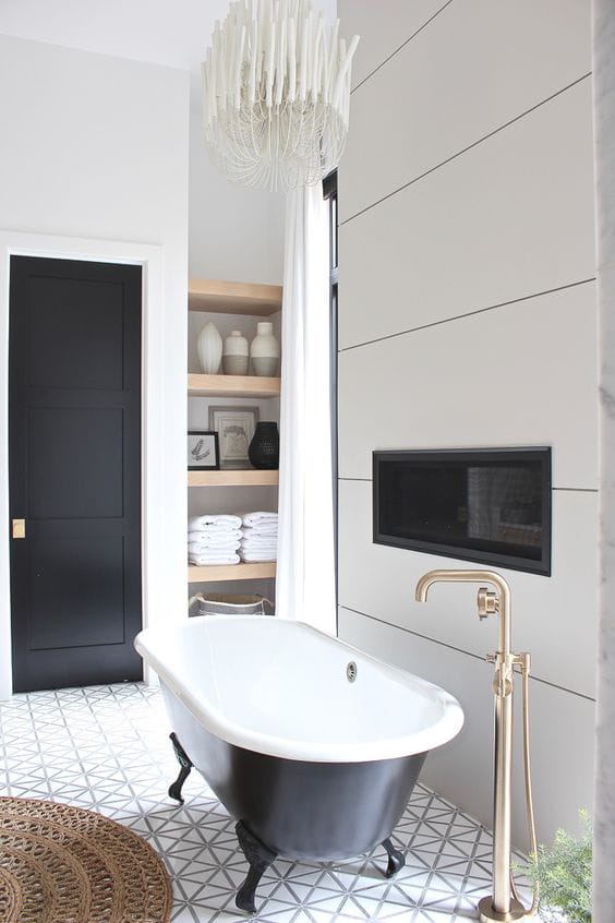 Une salle de bain en noir et blanc avec baignoire et cheminée.