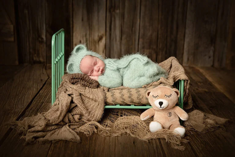 Nouveau-né endormi dans un petit lit vert