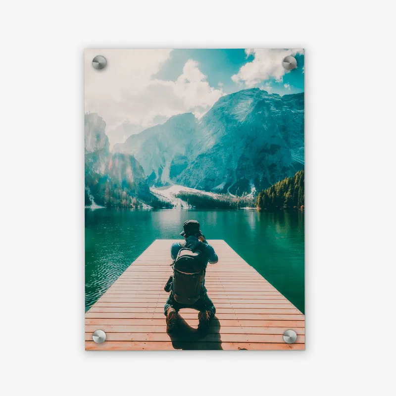 Une personne assise sur un quai regardant un lac.