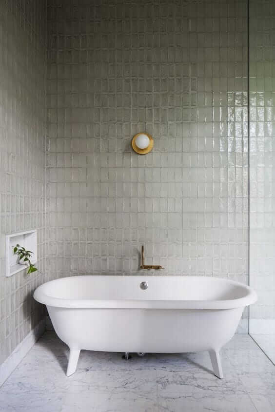 Une salle de bain avec une baignoire blanche et des murs carrelés.