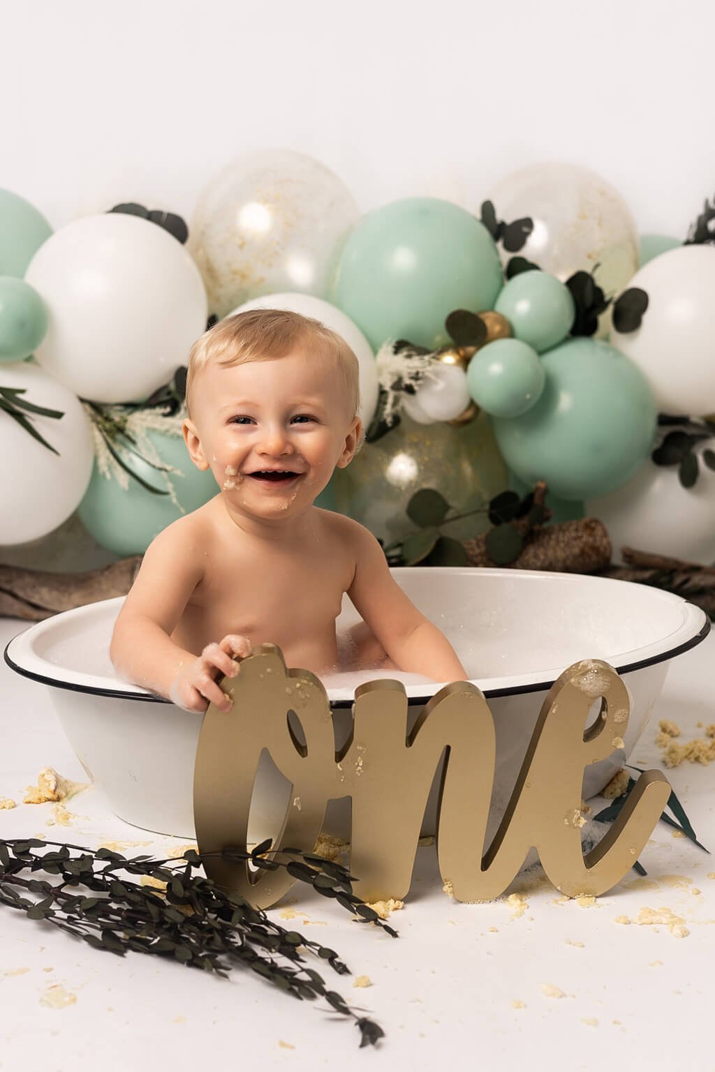 Un bébé assis dans une baignoire avec des ballons et un numéro 1 doré — Rébecca Vandal, photographe à Granby