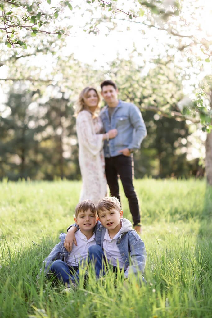 Une famille pose dans un verger de pommiers