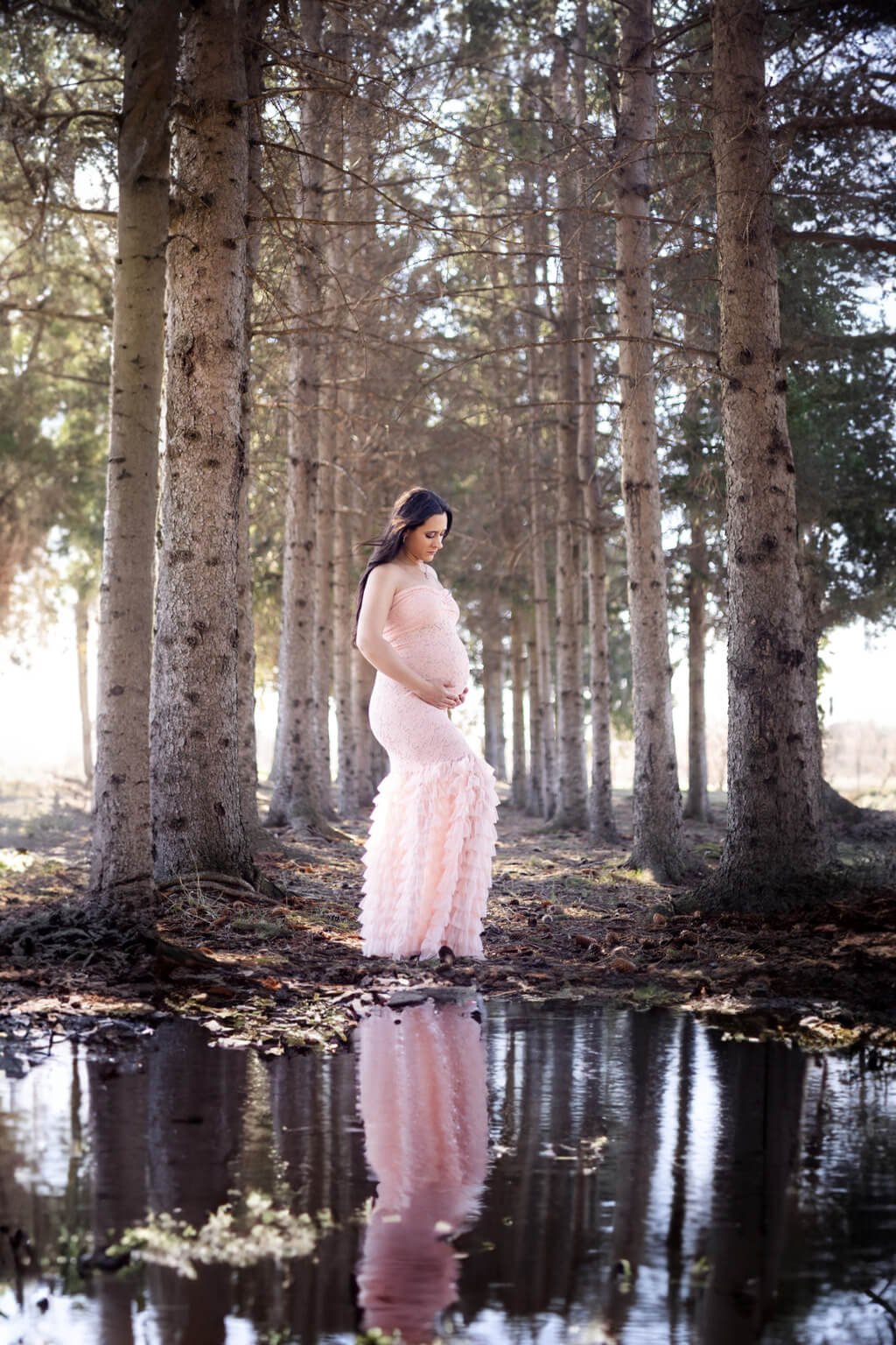 Une femme enceinte vêtue d'une robe rose debout dans une flaque d'eau — Rébecca Vandal, photographe à Granby