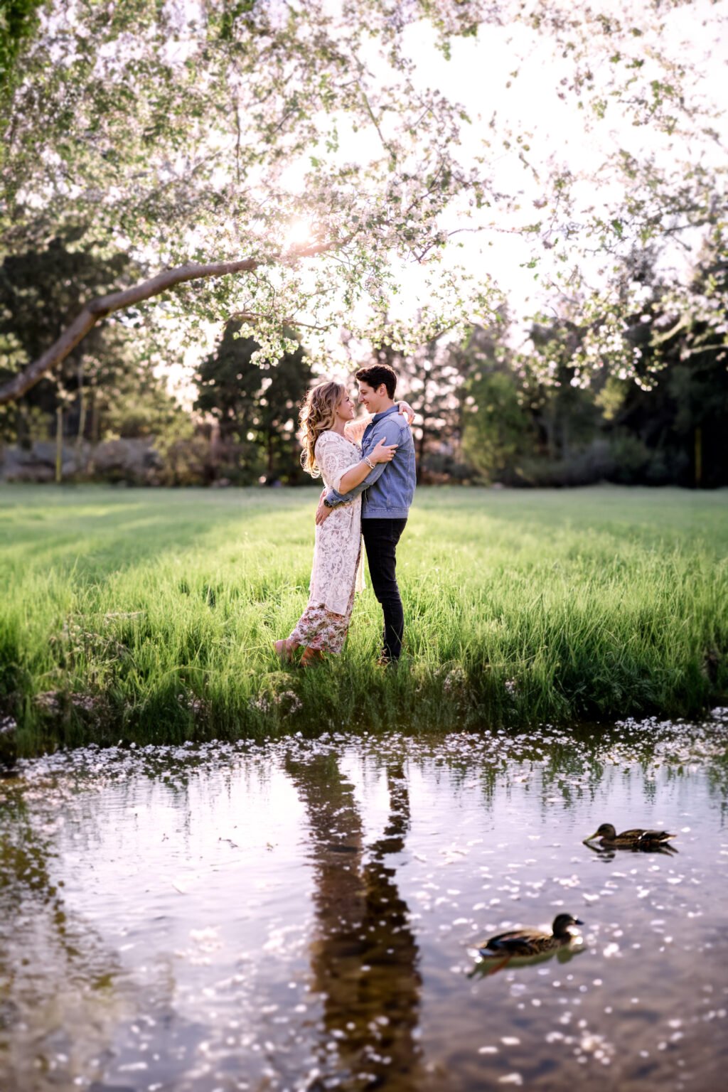 Couple enlacé au bord d’un étang, dans un verger en fleurs — Rébecca Vandal, photographe à Granby
