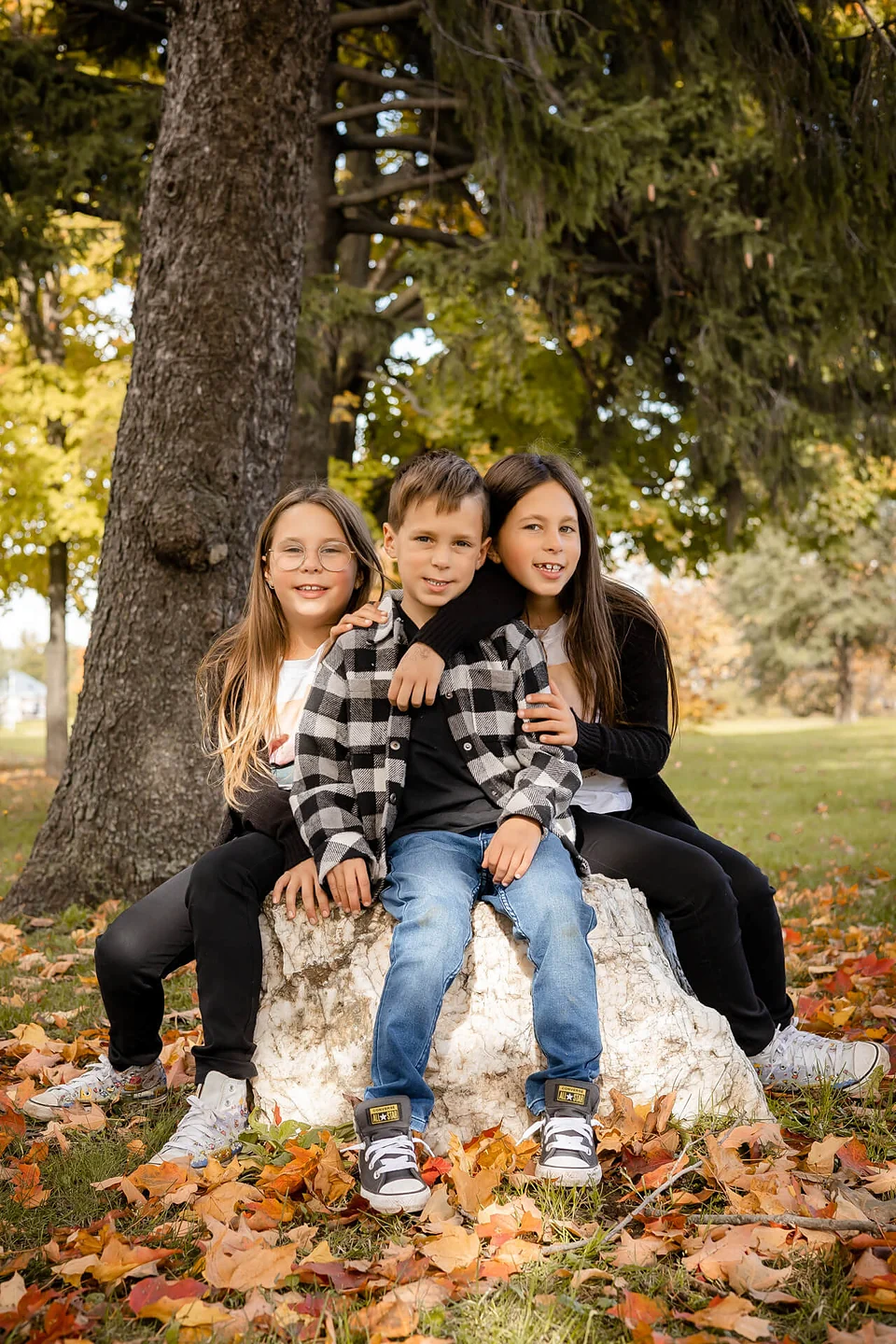 Trois enfants assis sur un rocher dans un parc — Rébecca Vandal, photographe à Granby