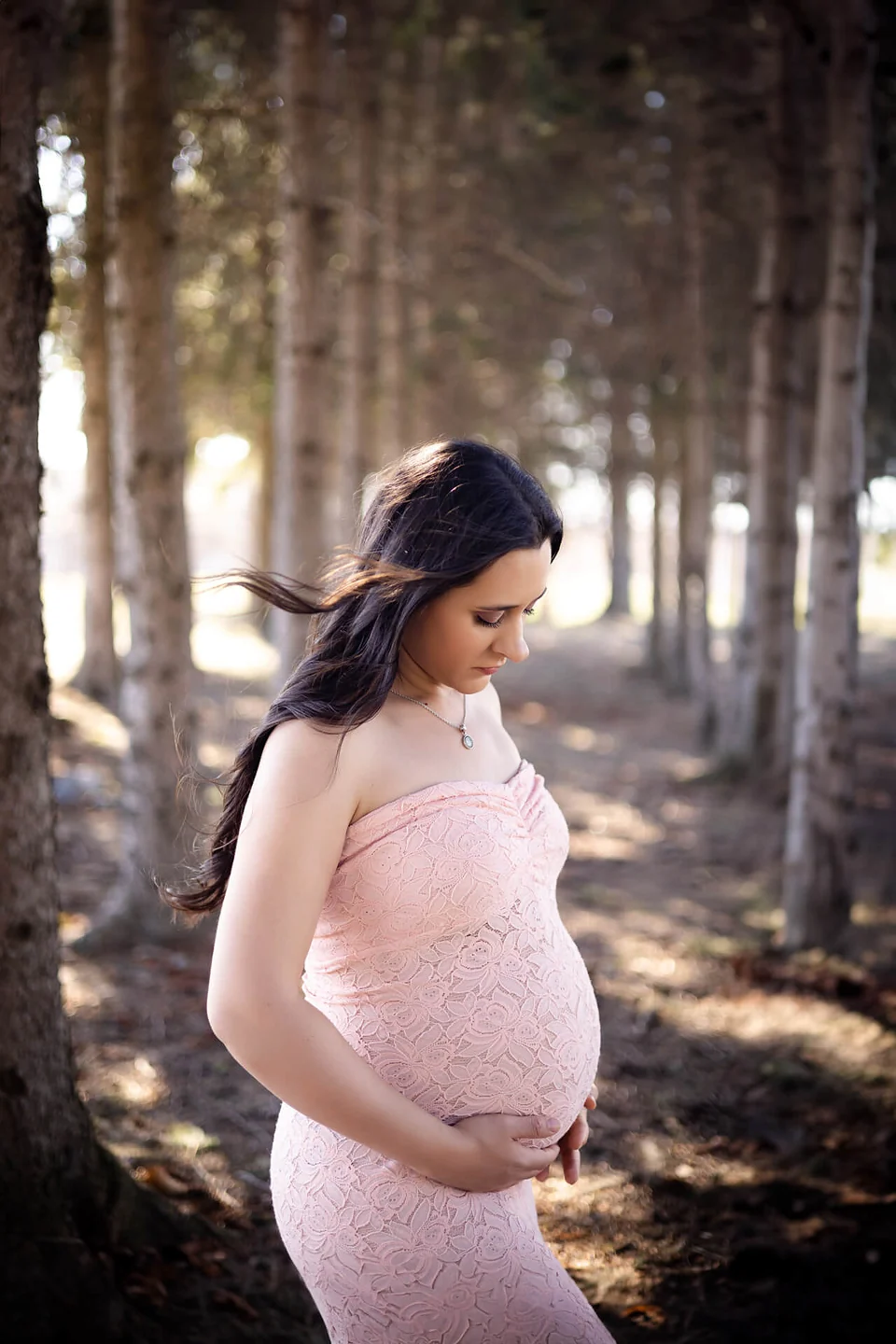 Une femme enceinte vêtue d'une robe rose debout dans les bois — Rébecca Vandal, photographe à Granby