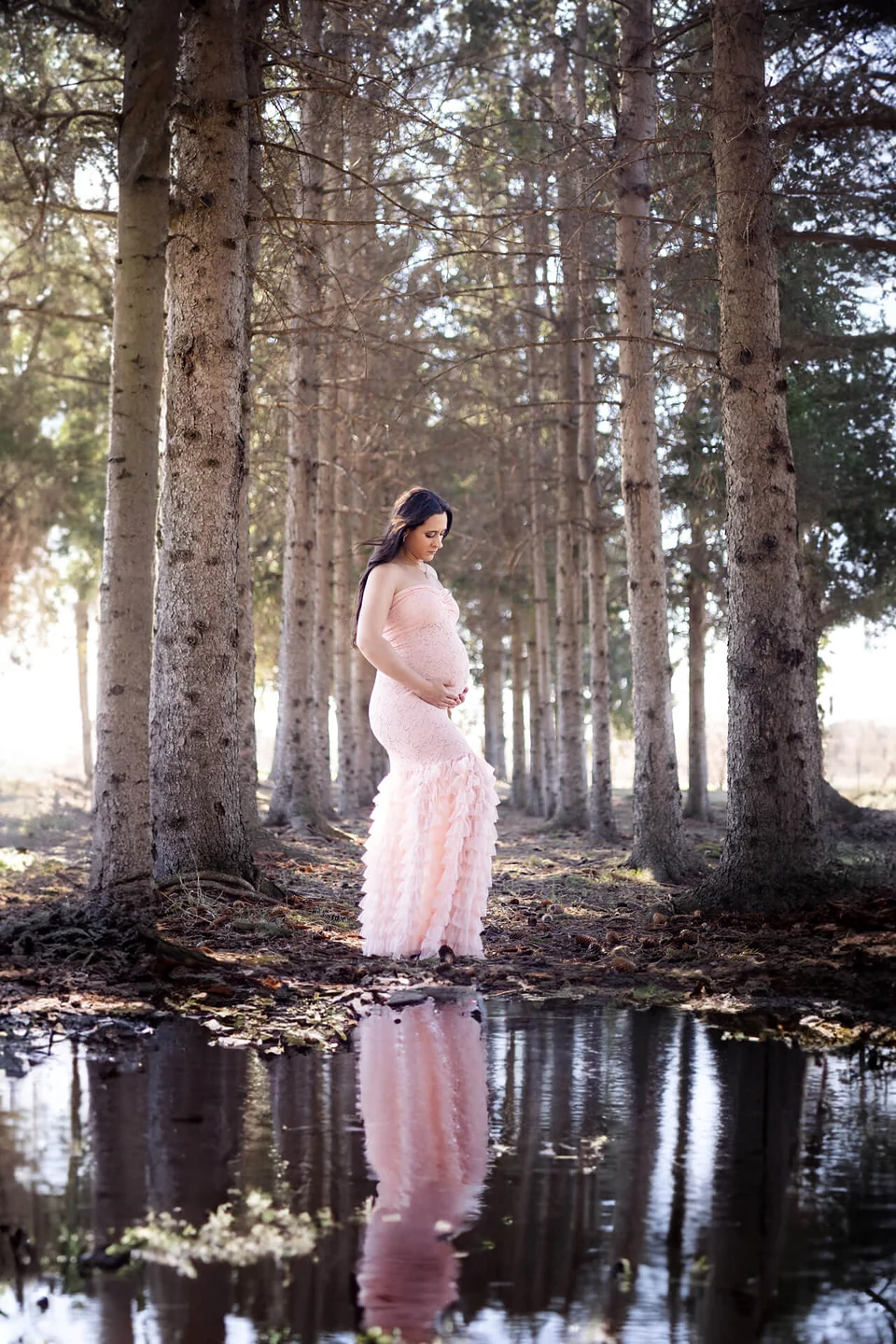 Une femme enceinte vêtue d'une robe rose debout dans une flaque d'eau — Rébecca Vandal, photographe à Granby