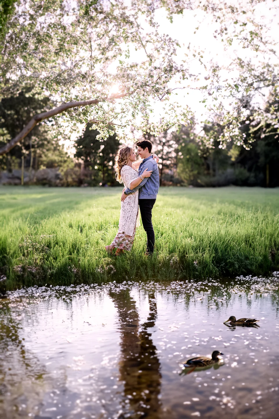 Couple enlacé au bord d’un étang, dans un verger en fleurs — Rébecca Vandal, photographe à Granby