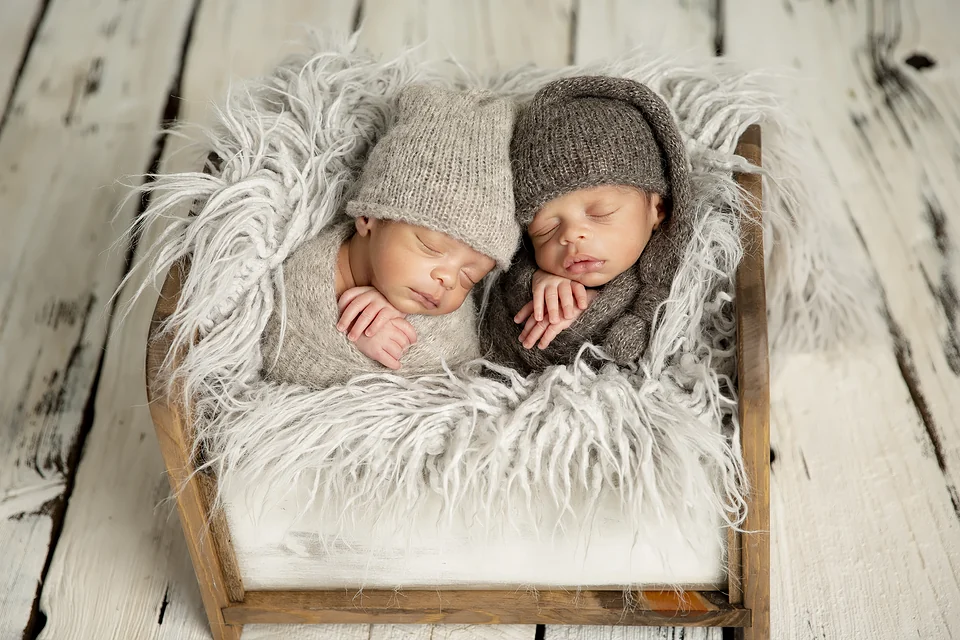 Jumeaux nouveau-nés endormis avec leurs bonnets dans un petit lit de bois — Rébecca Vandal, photographe à Granby