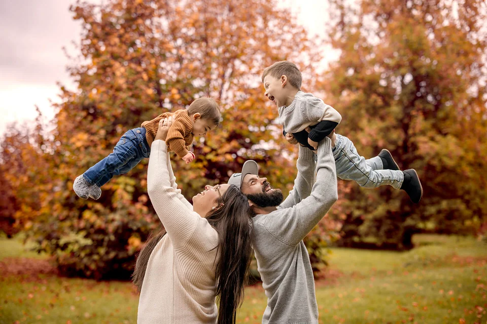 Une famille tient son enfant en l’air dans un parc — Rébecca Vandal, photographe à Granby